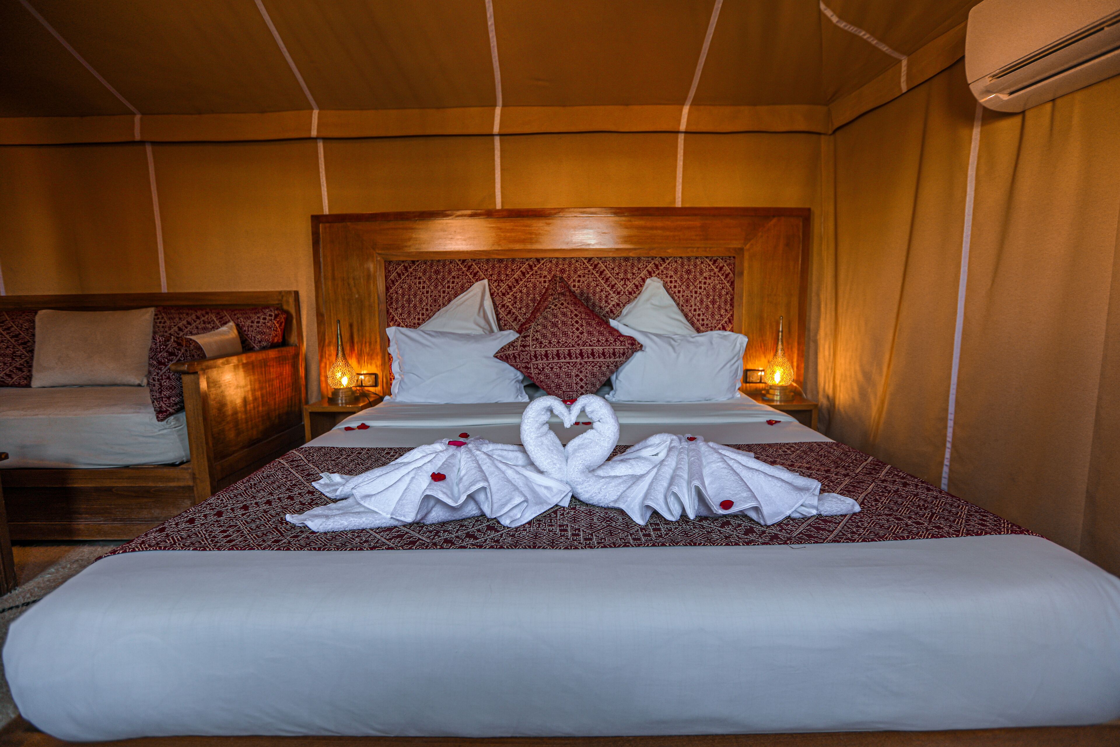 Una habitación de hotel con una cama grande, dos mesitas de noche y un cabecero de madera.