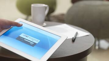 A tablet on a round table displaying a login screen.