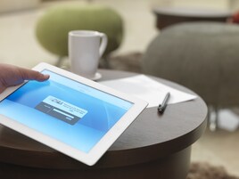A tablet on a round table displaying a login screen.