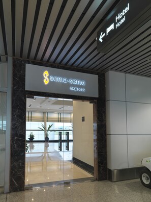 A hotel entrance with a sign reading "sama.sama express" and a directional sign pointing to the hotel. - Sama-Sama Express KLIA Terminal 1 - Airside Transit Hotel (Sepang)