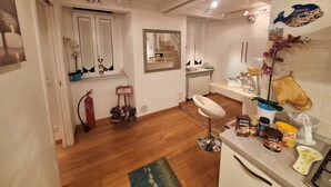 A kitchen with wooden flooring, a white countertop, and various kitchen appliances.