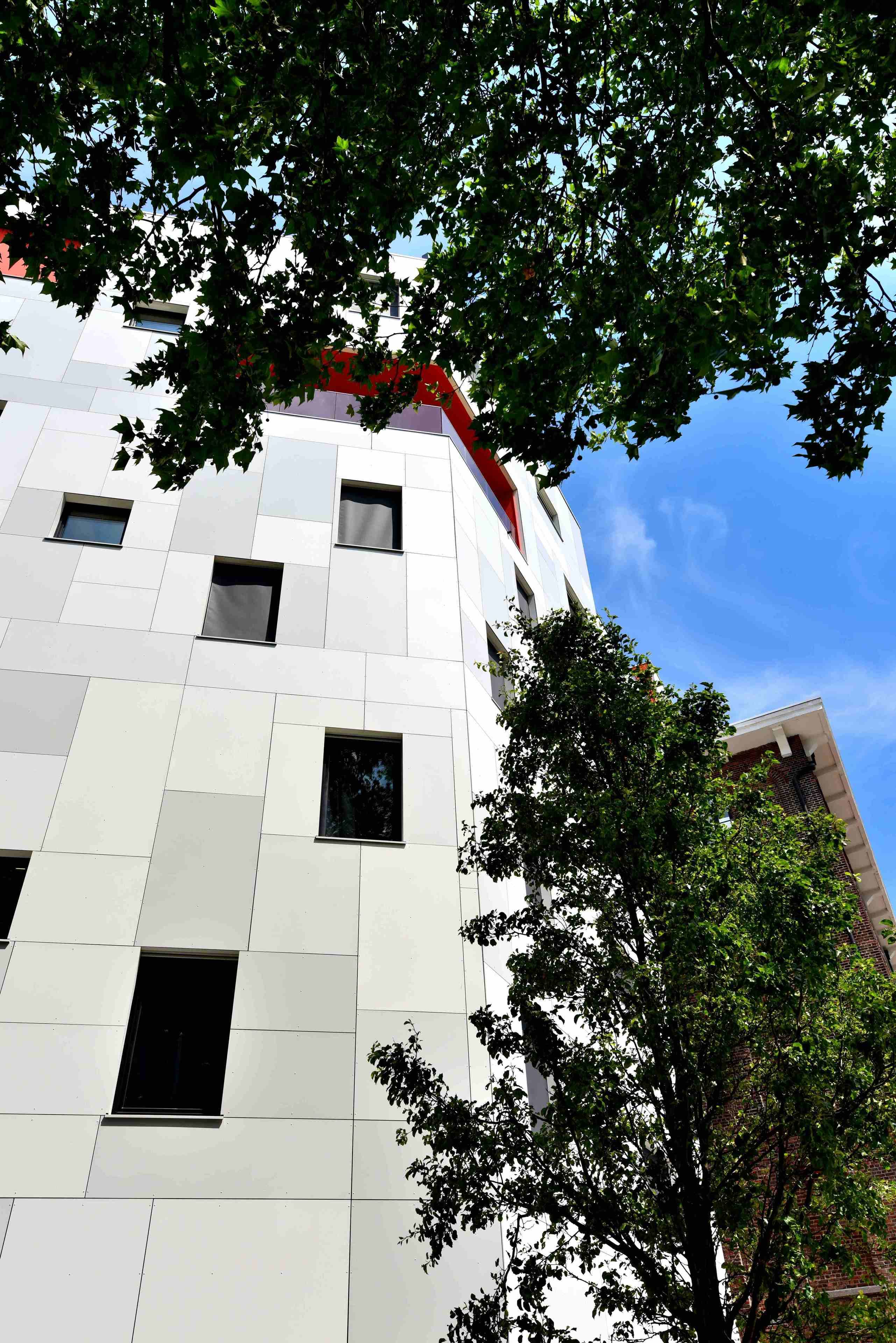 A modern building with a white facade and multiple windows.