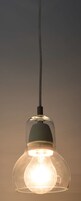 Una lampada a sospensione con paralume in vetro trasparente e un'etichetta ben visibile.