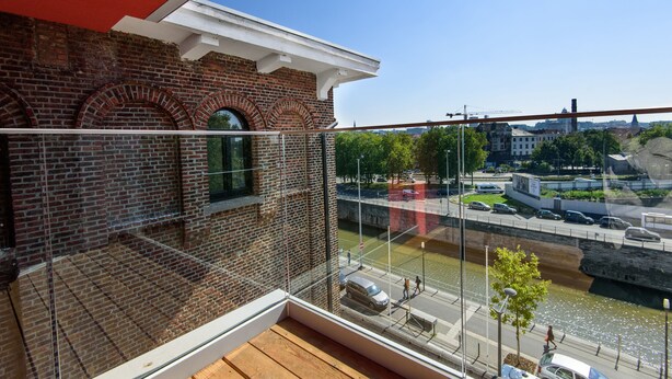 A balcony with a view of a river, a bridge, and a cityscape. - BELVUE Hotel (Brussels)