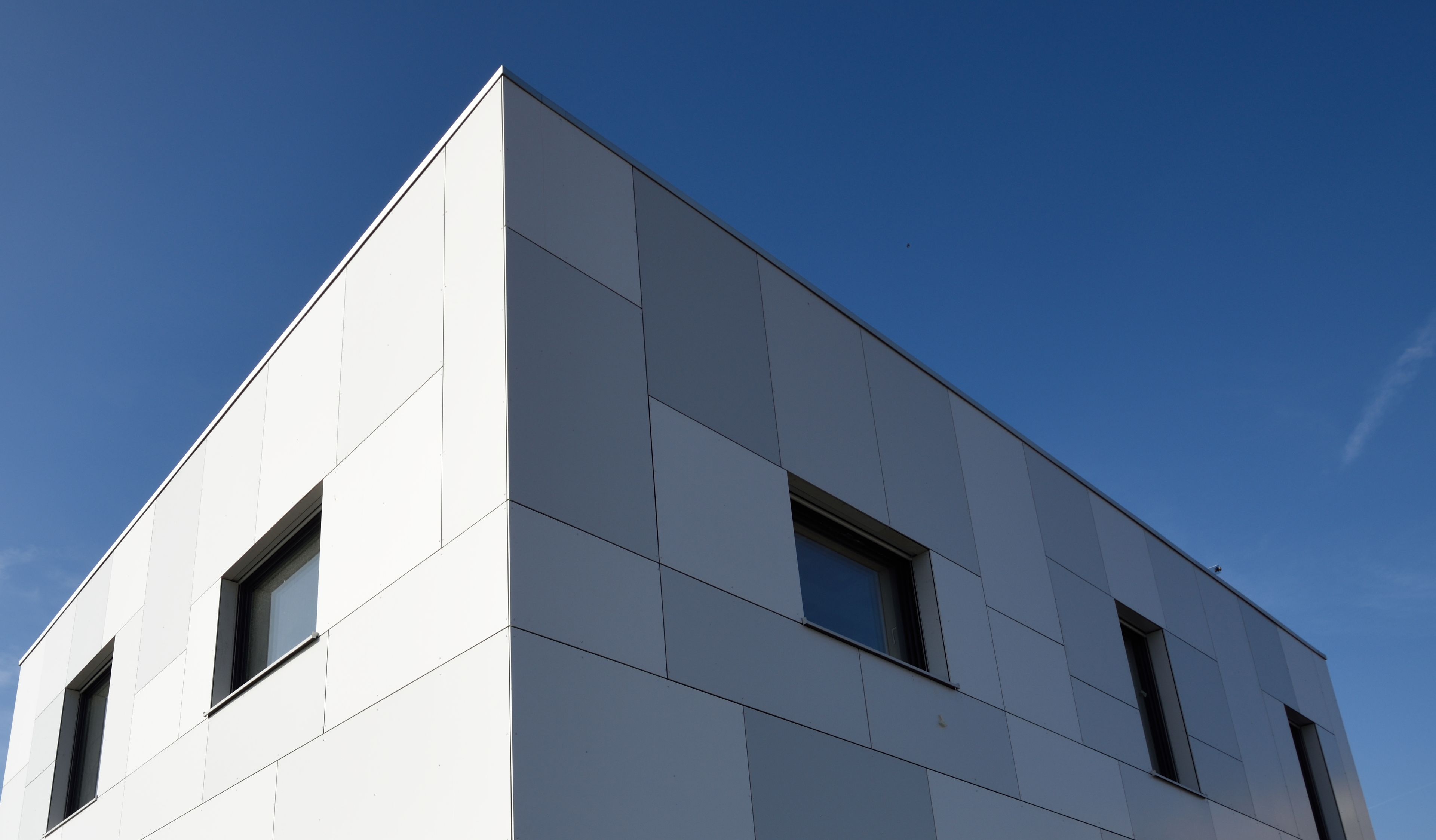 Un bâtiment moderne doté d’un toit plat et d’une façade aux lignes géométriques.