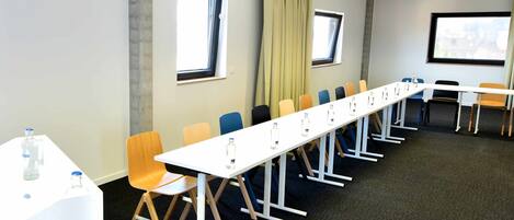 A conference room with a long table, chairs, and a projector.