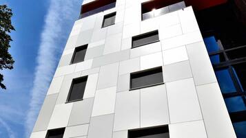 Un bâtiment moderne à la façade blanche et doté de nombreuses fenêtres.