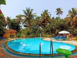 Una piscina al aire libre, sillones reclinables de piscina