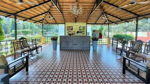 A covered outdoor area with a reception desk, seating, and a patterned floor. - Carina Beach Resort (Benaulim)