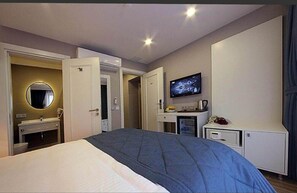 أغطية فراش متميزة وميني بار وخزنة داخل الغرفة ومكتب