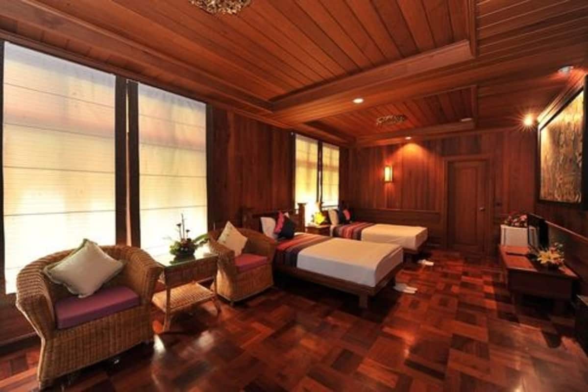 Ein Zimmer mit Holzboden, zwei Betten, einer Couch und einem kleinen Tisch.
