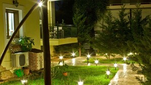 A well-lit outdoor area with a stone pathway, a reception desk, and a brick fireplace.