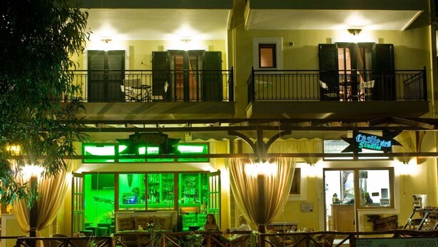 A multi-story building with a bar area featuring green lighting and a sign reading "Castle View Studios."