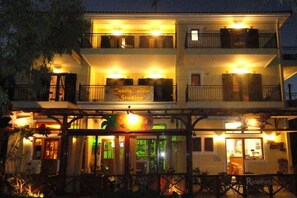 A two-story building with a sign reading "Castle View Studios." It features balconies, a reception area, and a dining area with outdoor seating. - Castle View Studios (North Kynouria)