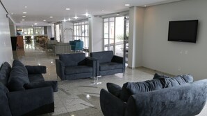 Un hall d’entrée spacieux, doté de meubles modernes, d’un téléviseur à écran plat et de grandes fenêtres.