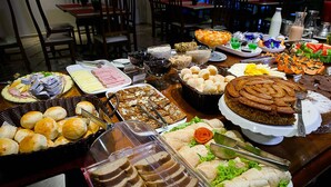 Une table de buffet proposant divers plats, notamment des sandwichs, des pâtisseries et des desserts.