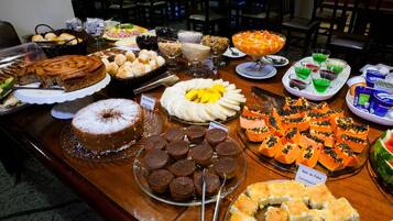 Ein reichhaltiges Buffet mit verschiedenen Speisen, darunter Kuchen, Gebäck und eine Auswahl an Desserts.