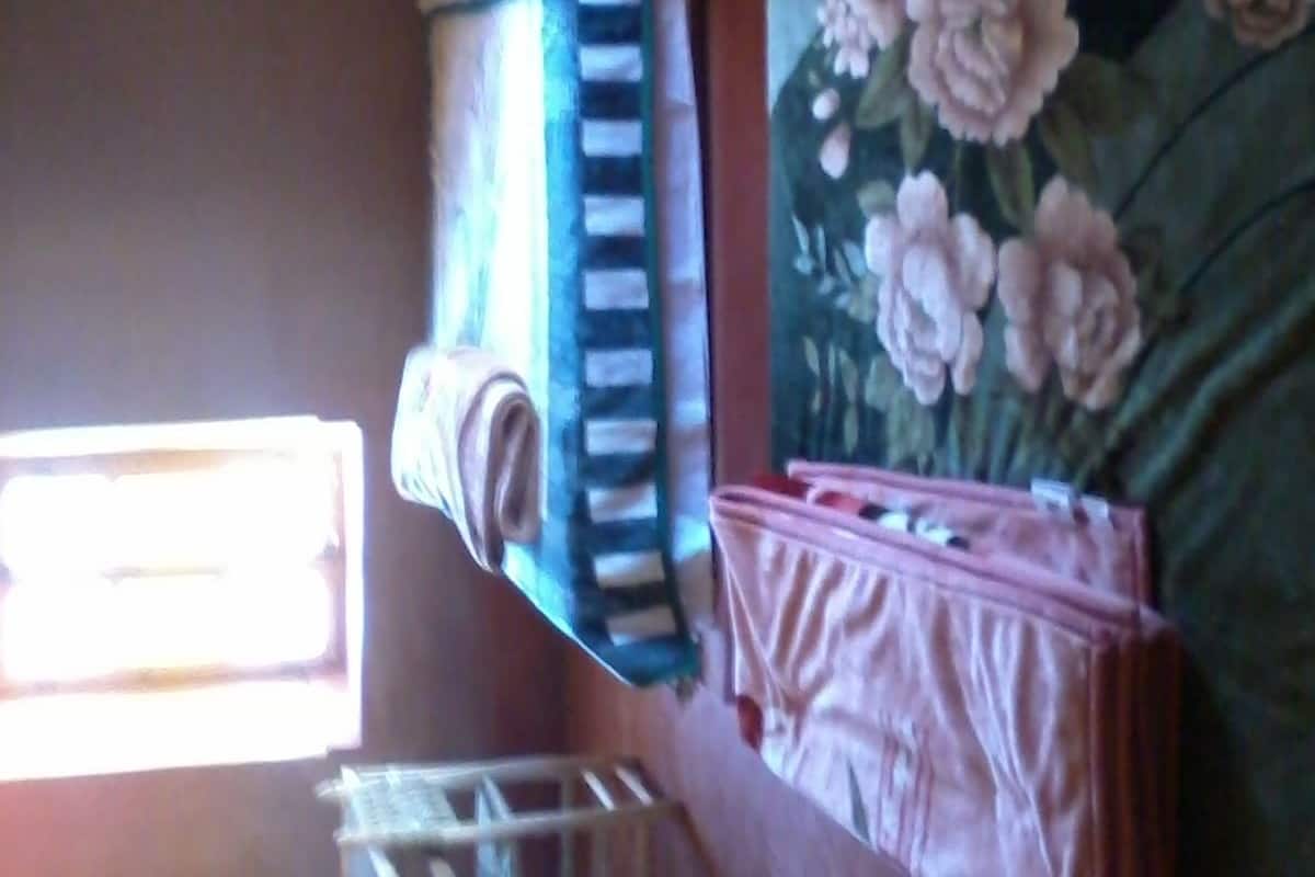 Une petite pièce, de taille modeste, comprenant un lit superposé, une petite table et une fenêtre qui laisse entrer la lumière naturelle.