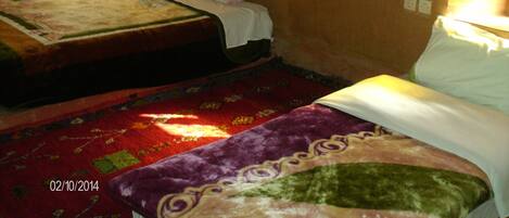 A room with two beds, a bookshelf, and a patterned carpet.