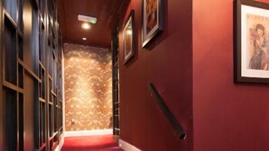 Un escalier recouvert d’une moquette rouge menant à un palier.