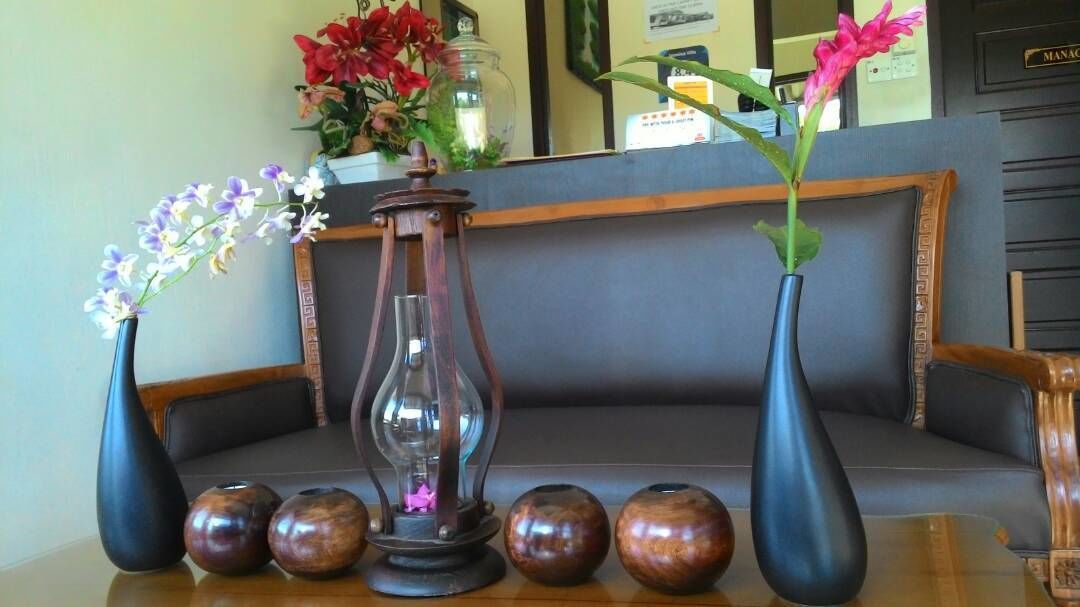 Uma área de recepção com sofá, vasos e flores.