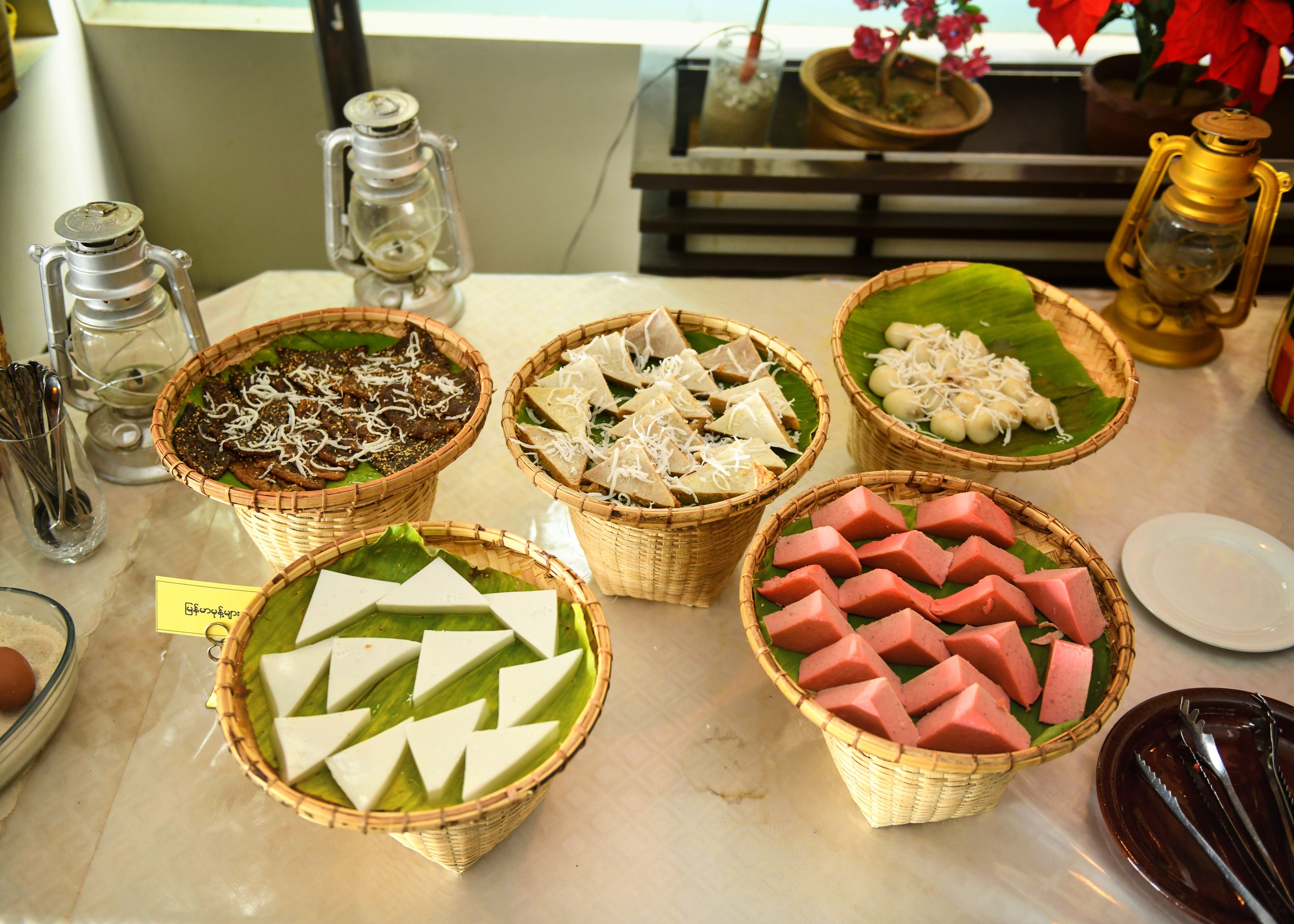 A buffet table with various food items arranged in baskets.