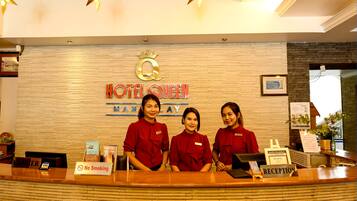A hotel reception desk with a "No Smoking" sign, a "Cashier" sign, and a "Reception" sign.