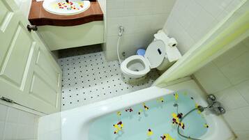 A bathroom with a bathtub, toilet, sink, and shower.