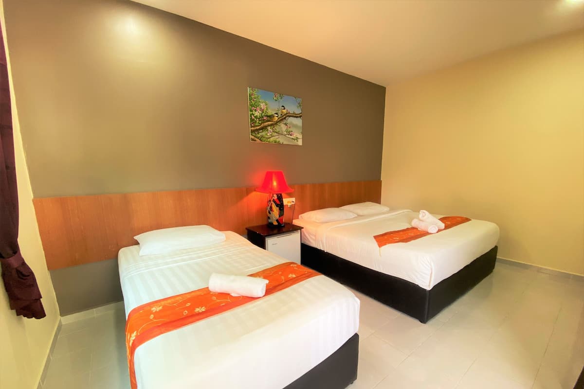 A hotel room with two beds, a nightstand with a lamp, and a painting on the wall.