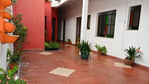 A covered outdoor area with potted plants and a tiled floor. - Hotel La Giralda (Salta)