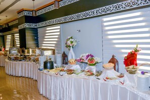 A buffet setup with various food items and decorative elements. - Reef Global Hotel (Makkah)
