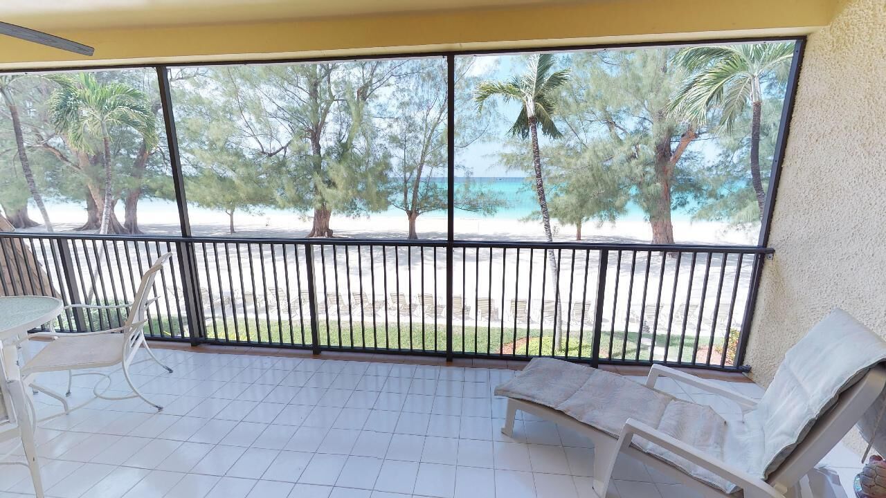 Un balcón con vista a una playa y palmeras.