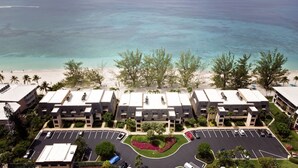 A beachfront hotel with multiple buildings, a parking lot, and a sandy beach. - The Islands Club (Seven Mile Beach)