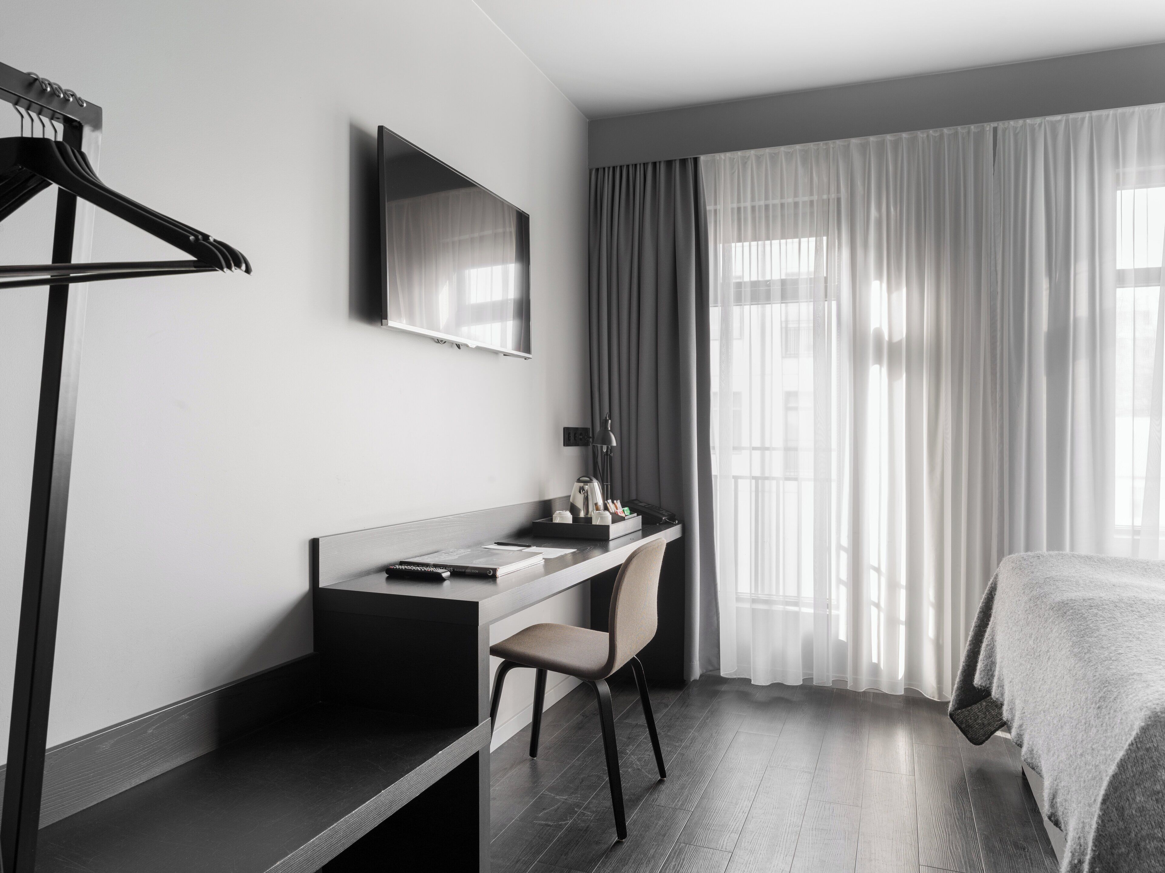 Una habitación de hotel moderna con escritorio, silla y cama.