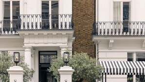 A building with a black door, white columns with the number 8, and a black and white awning. - The Laslett Hotel (London)