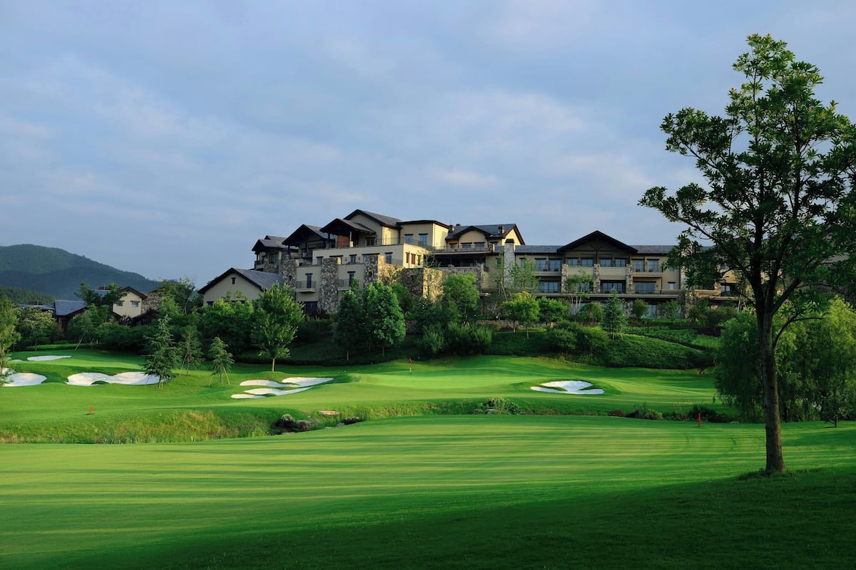 Un terrain de golf avec un grand bâtiment en arrière-plan.
