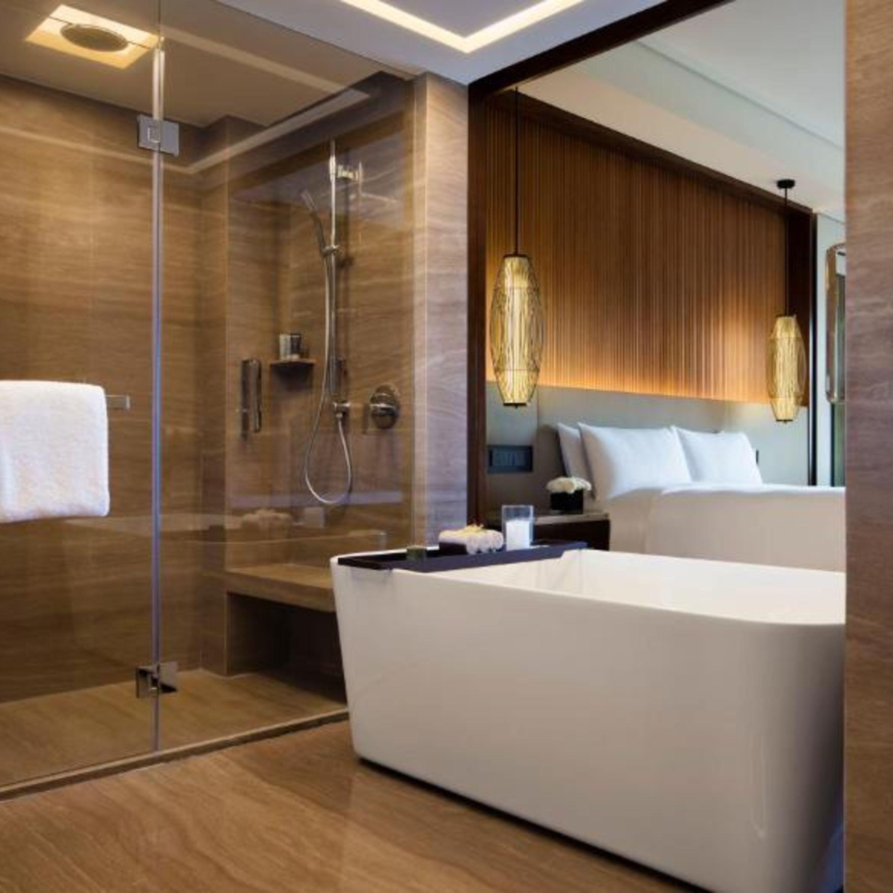 Un baño moderno con ducha a ras de suelo, bañera amplia y tocador con espejo.