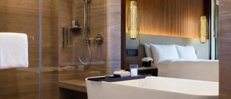 Un baño moderno con ducha a ras de suelo, bañera amplia y tocador con espejo.