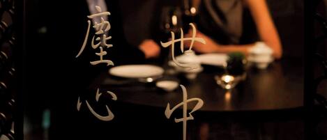 A couple seated at a table in a dimly lit room with traditional decor.