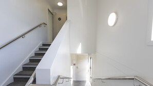 Un escalier moderne avec des rampes en métal et une porte en haut.