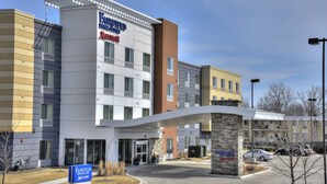 A Fairfield Inn & Suites hotel with a modern design, featuring a prominent entrance and a parking area.