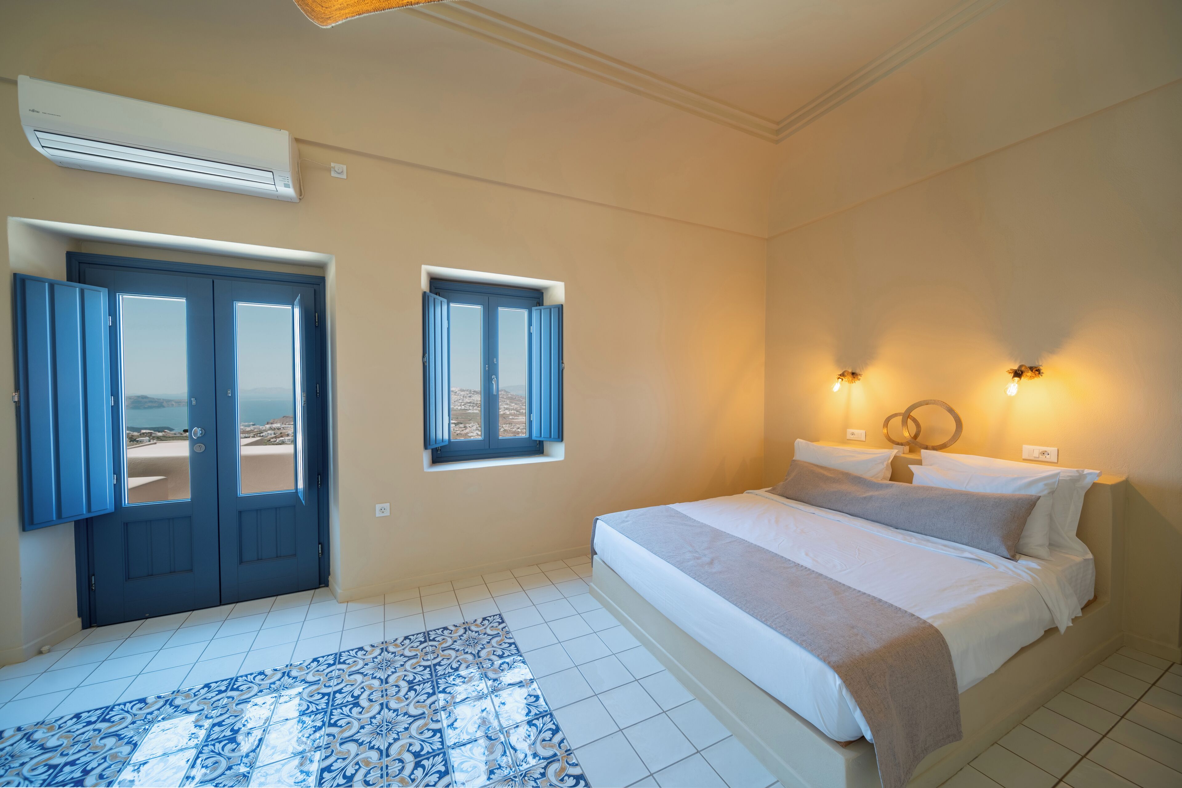 A bedroom with a bed, a window, a door, and an air conditioning unit.