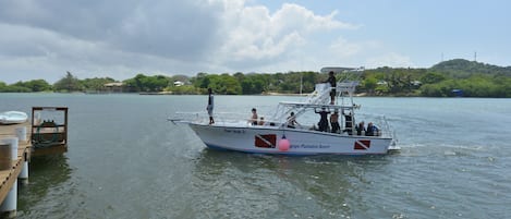 Ein Boot mit Passagieren an einem hölzernen Steg.