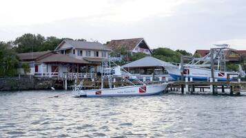 Un barco amarrado llamado 'Seagrove Plantation Resort' en un puerto deportivo, con casas al fondo.