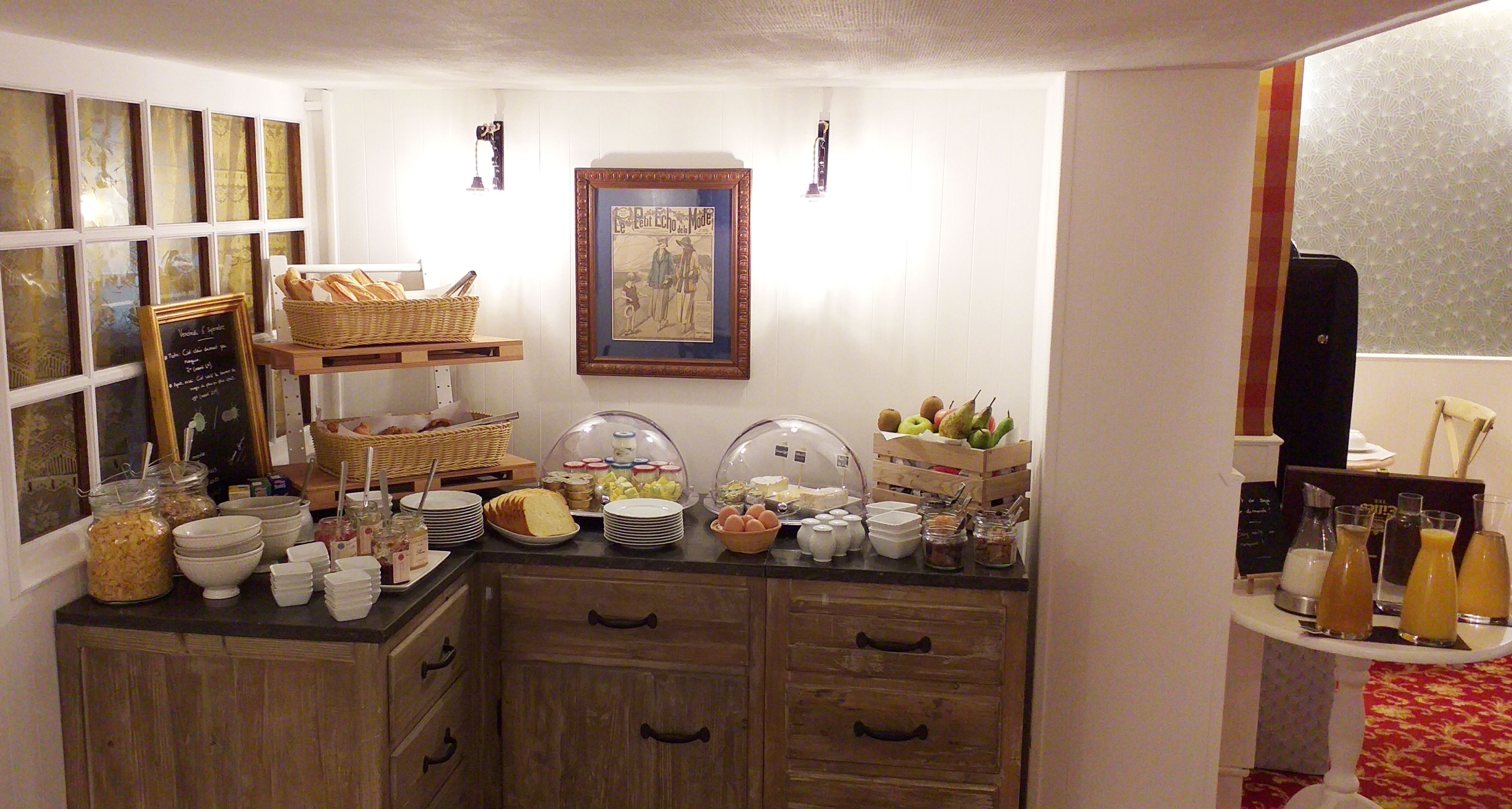 Un buffet de petit-déjeuner avec divers plats et une image encadrée accrochée au mur.