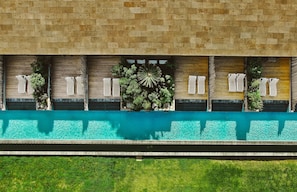 Una piscina al aire libre, sillones reclinables de piscina