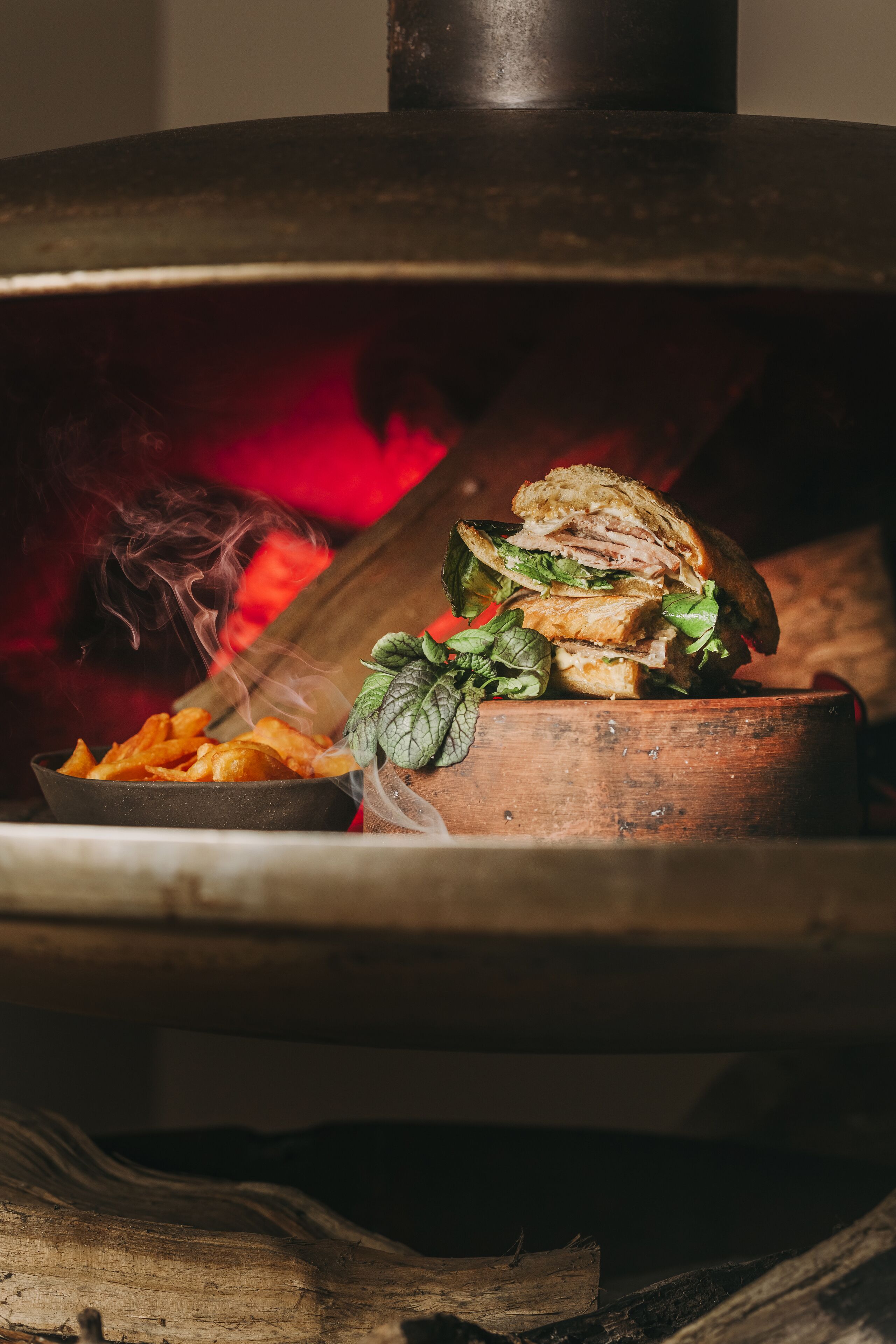 Un horno de leña con un sándwich cocinándose en su interior.