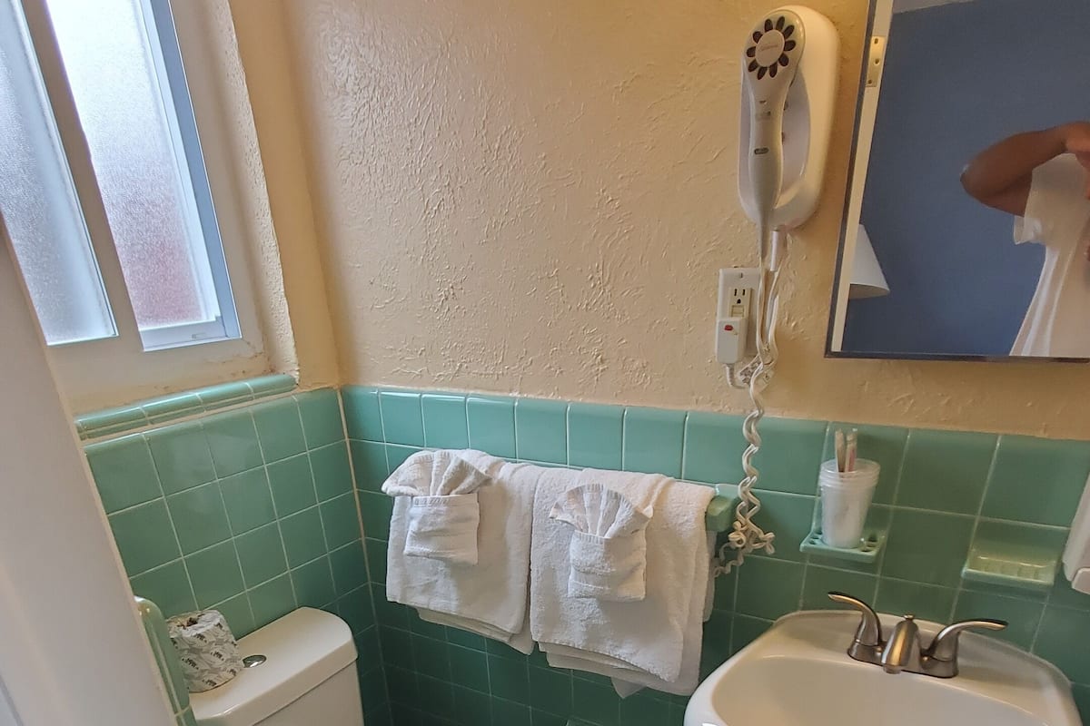A bathroom with a toilet, sink, and towel rack.