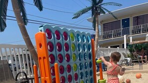 A child playing with a colorful ball toss game. - Sand Box Motel (Wildwood)