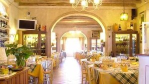 A restaurant with a long, central aisle leading to a counter, tables with yellow tablecloths, and a warm, wooden interior. - La Meridiana (Lanuvio)